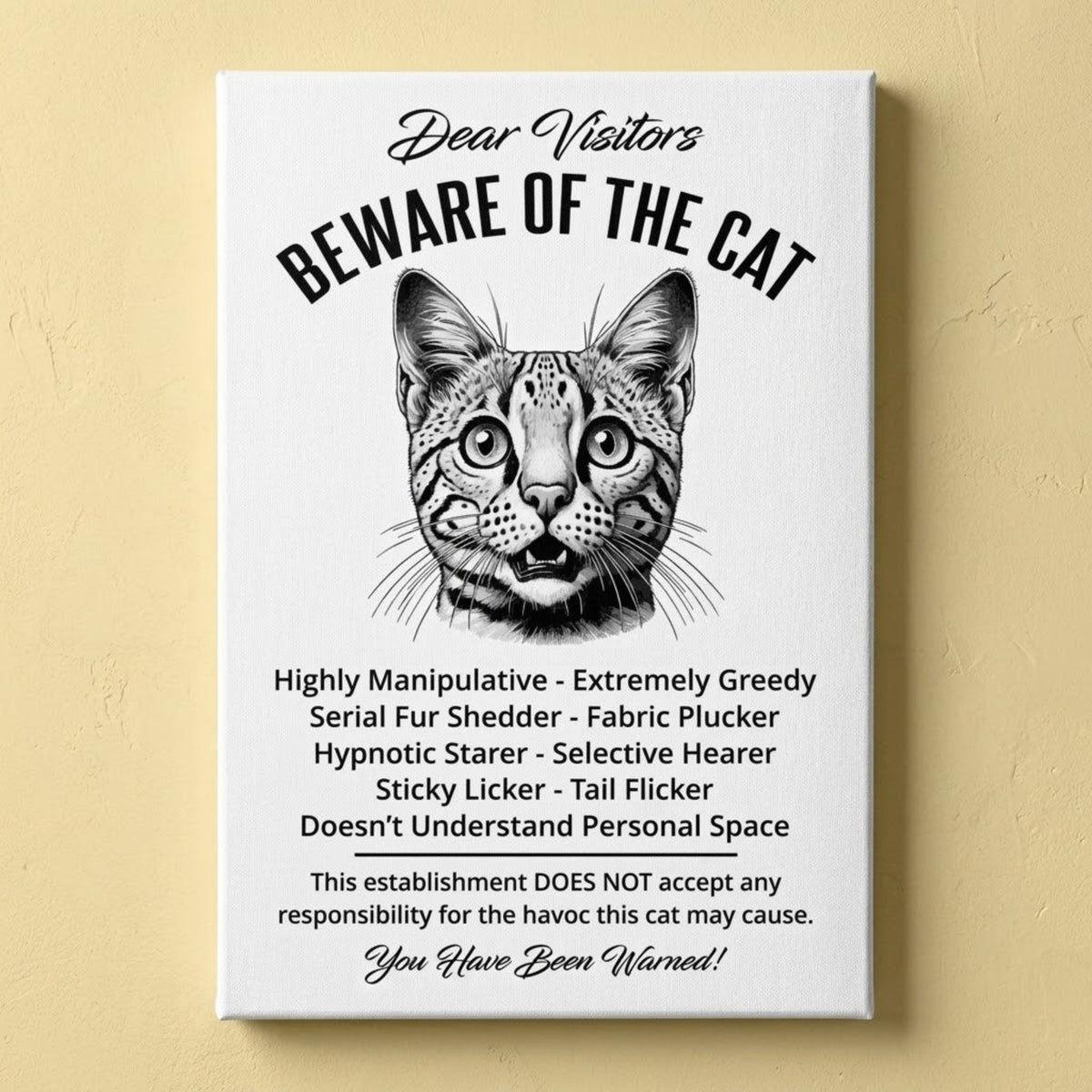A rectangular white canvas sign with black printed funny text warning visitors about a Savannah cat, featuring a black-and-white illustration and humorous behavioral descriptions. The canvas print is photographed against a yellow wall.
