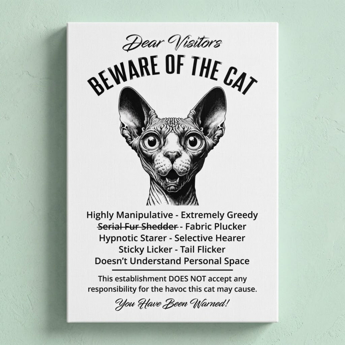 A rectangular white canvas sign with black printed funny text warning visitors about a Sphynx cat, featuring a black-and-white illustration and humorous behavioral descriptions. The canvas print is photographed against a light green wall.