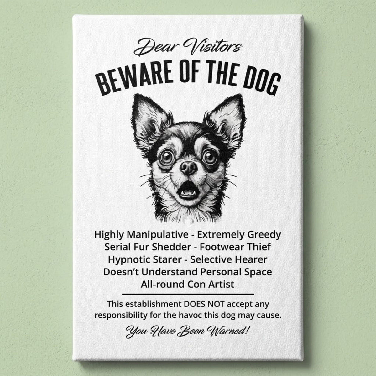 A rectangular white canvas sign with black printed funny text warning visitors about a Chihuahua dog, featuring a black-and-white face illustration and humorous behavioral descriptions. The canvas print is photographed against a light green wall.