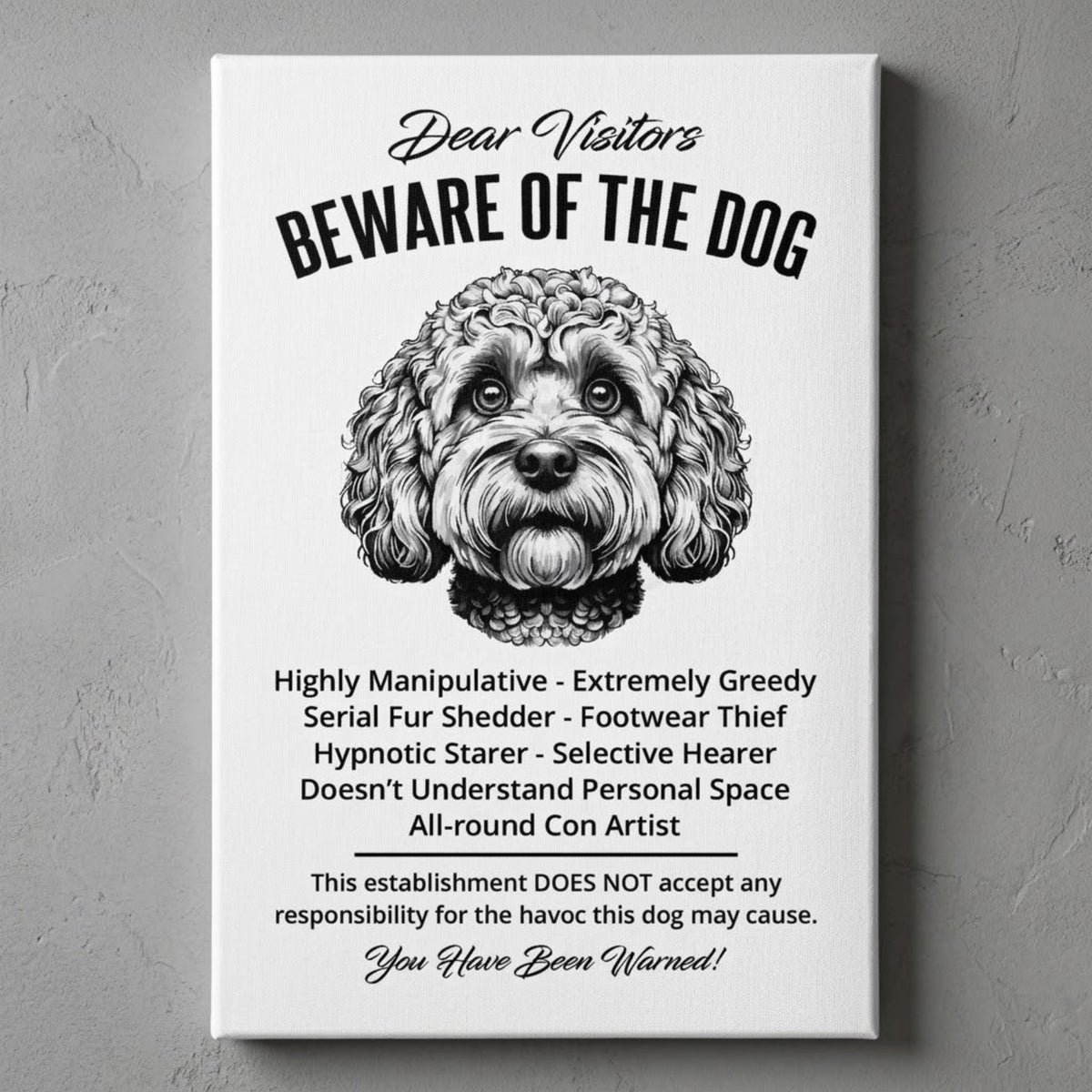 A rectangular white canvas sign with black printed funny text warning visitors about a Cockapoo dog, featuring a black-and-white face illustration and humorous behavioral descriptions. The canvas print is photographed against a gray plastered wall.
