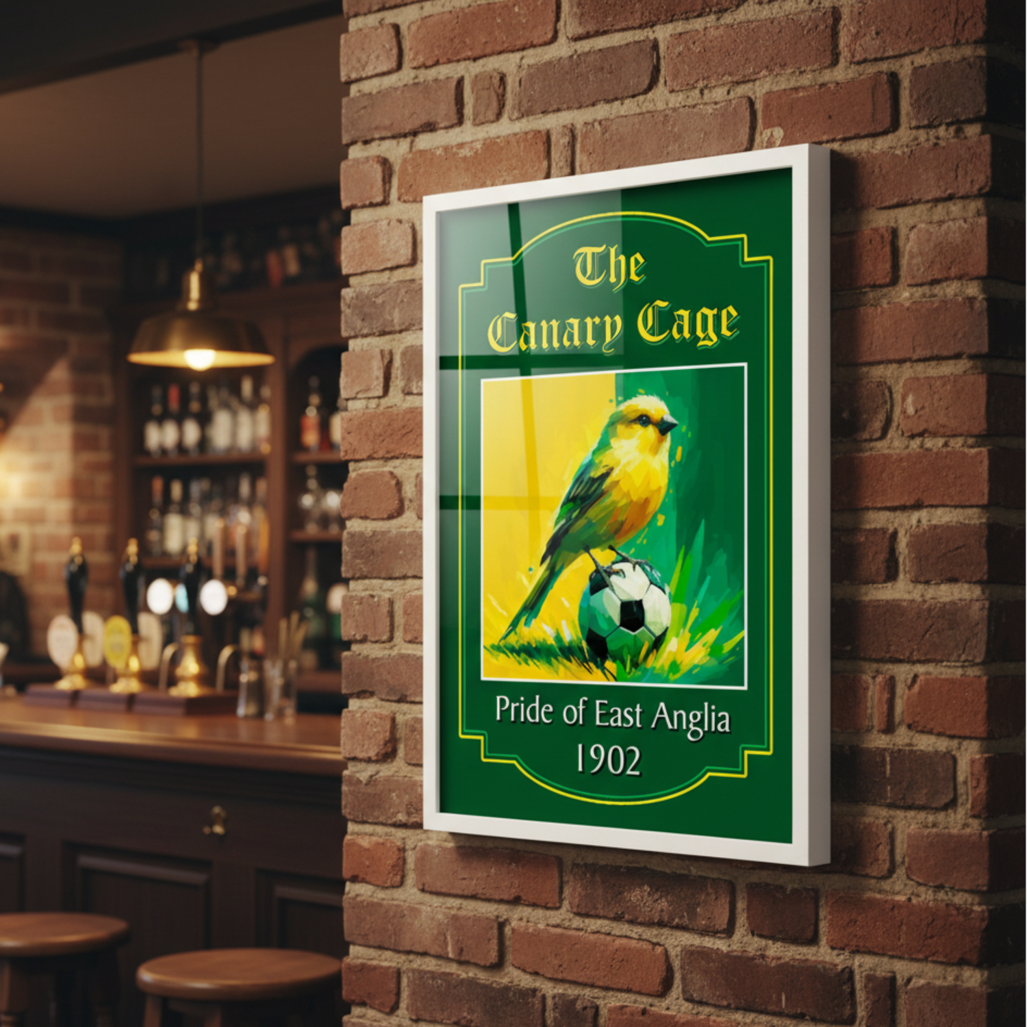 Framed Norwich City FC art print 'The Canary Cage' text, displayed on a brick wall in a bar setting.